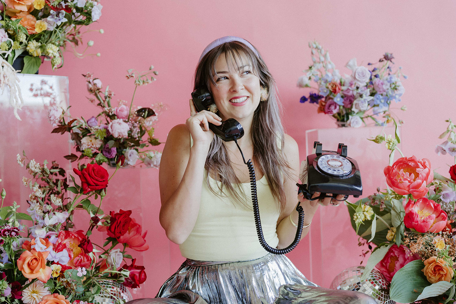 Guest in pink floral setting leaving a message on a vintage rotary phone