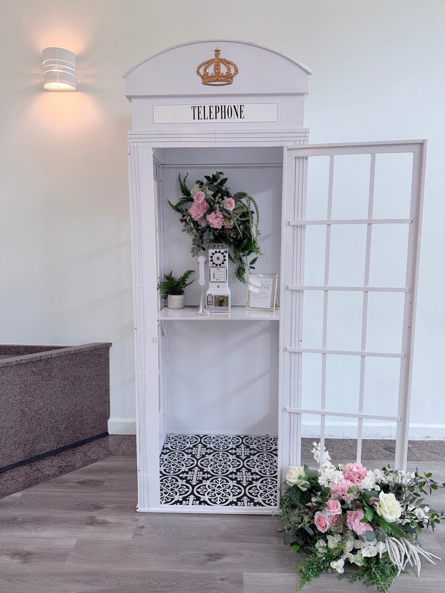 Well Wishes crowned white telephone booth styled with florals