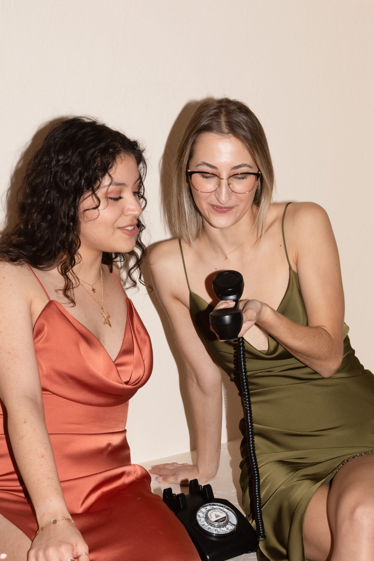 Two guests in silk dresses recording an audio guestbook message together