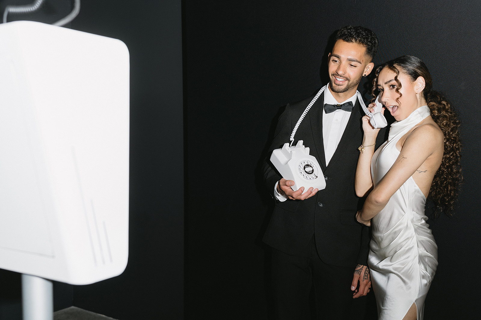 Elegant couple recording a late-night message at a Well Wishes booth
