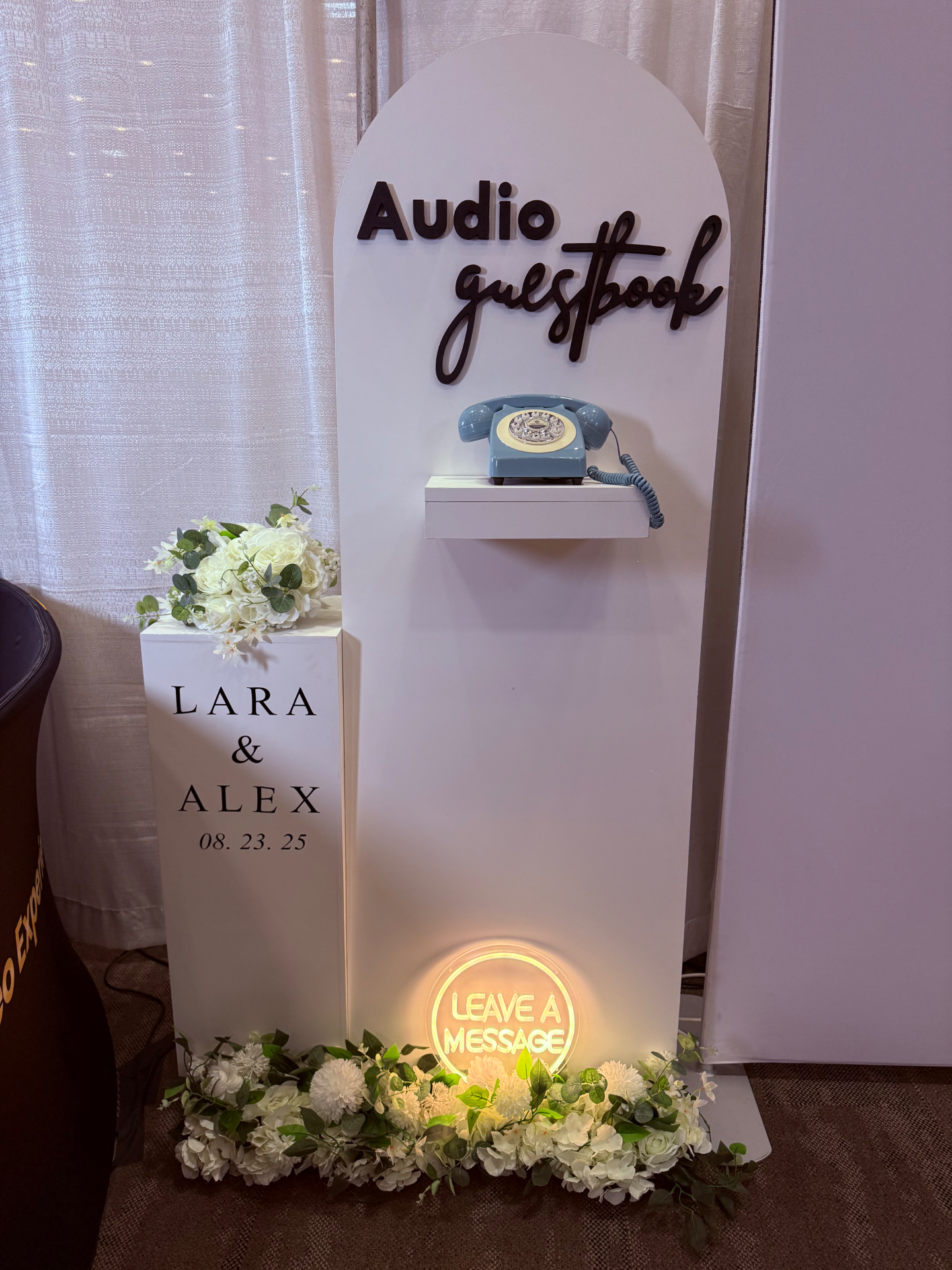 The Signature Wall audio guestbook setup with floral backdrop